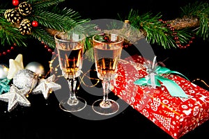 New Year holiday concept. New Year\`s decor - champagne glasses, a gift, New Year\`s toys, a Christmas tree with decorations