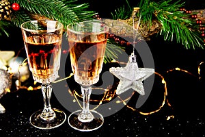 New Year holiday concept. New Year\'s decor - champagne glasses, a gift, New Year\'s toys, a Christmas tree with decorations. Clos