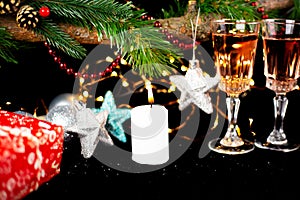 New Year holiday concept. New Year\'s decor - champagne glasses, New Year\'s toys, a Christmas tree with decorations, a candle is