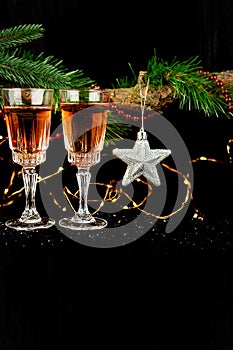 New Year holiday concept. New Year`s decor - champagne glasses, New Year`s toys, a Christmas tree with decorations. Place for an