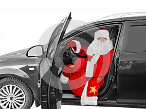 New Year holiday. Santa Claus - the driver sits behind the wheel of the car with a bag of gifts.