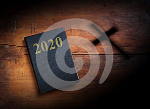 2020 New year. Holy Bible with 2020 text on wooden background. 3d illustration