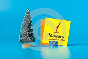 New year. January 1st. Day 1 of december month, calendar with little christmas tree on blue background. Winter time