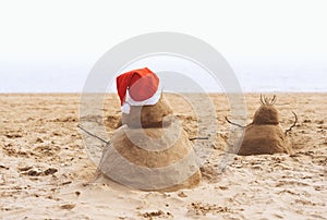 New Year or Merry Christmas sand snowman on ocean beach