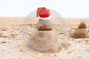 New Year or Merry Christmas sand snowman on ocean beach