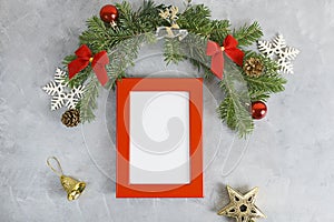 New year mockup: christmas tree branches with red photo frame on grey background. Holidays concept
