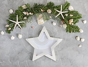 New year mockup: pine tree branches with star shaped photo frame on grey background. Tropical christmas, holidays concept
