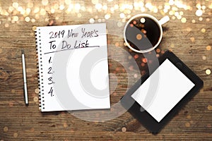 New year Motivation in 2019 Concept. Number and text on notepad. Tablet, pen and cup of copy background, top view, flat lay with l