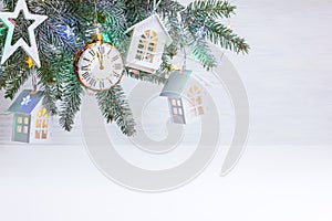 New year ornaments with christmas tree branch, decorative toy stars, houses, clock and color garland lights