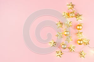 New Year party festive background - christmas tree of golden glossy and sparkling balls, ribbon, stars lights garland on pink.