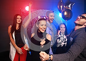 New year party, holidays, celebration, nightlife and people concept - Young people having fun dancing at a party