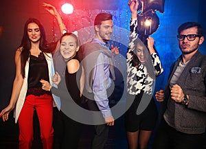 New year party, holidays, celebration, nightlife and people concept - Young people having fun dancing at a party