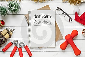 New year resolutions or goals for healthy lifestyle, lose weight and join gym. New Year`s resolutions written in notebook with