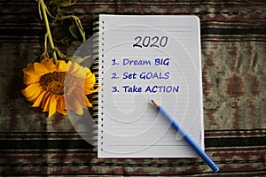 2020 new year resolutions list. Dream big. Set goals. Take action. Selfie Notes on notebook with flat lay concept.