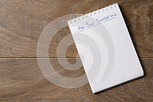 New year resolutions tempate with notepad on wood table