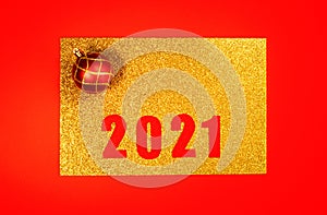 New year's background in 2021. Golden frame with numbers and a toy on a red background. A aplace for text