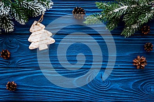 New year`s background. Christmas toys, spruce branches, pine cone on blue wooden background top view copyspace