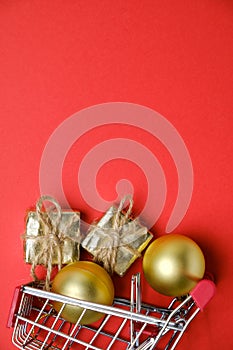 New Year`s balls, gifts with twine in toy shopping basket with copy space