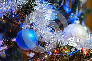 New Year\'s blue ball on a Christmas tree with shiny tinsel and garland