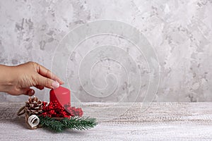 New year`s card with the process of creating decorations from a white candle and Christmas tree brunch