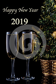 New Year`s celebration background with a pair of glasses of champagne and Christmas tree.