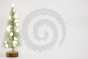 New Year`s and Christmas. Green Christmas tree with blurred lights on a white background.