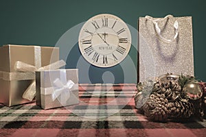 New Year\'s Christmas retro composition. Stylization of the past. Still life. Wall clock, winter blanket, boxes and gift bag