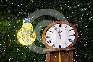 New Year`s clock and a big bright light bulb. On the dial without five twelve