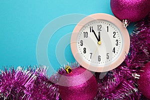 New Year`s clock decorated with christmas tinsel and ball. Celebration Concept for New Year Eve