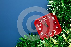 New Year`s clock decorated with christmas tinsel. Celebration Concept for New Year Eve