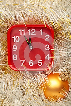 New Year`s clock decorated with christmas tinsel. Celebration Concept for New Year Eve