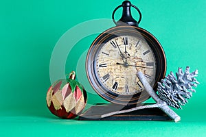 New Year`s clock midnight, bauble and cone on pine fir tree bran