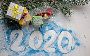 New Year`s composition. Christmas tree branches on a blue wooden background with artificial snow. Christmas tree decorated with