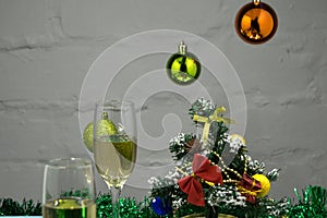 New Year`s composition. New Year champagne glasses, gifts and Christmas tree balls are on the table closeup