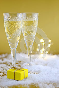 New Year`s composition: Two glasses with champagne on a gold bac