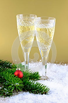 New Year`s composition: Two glasses with champagne on a gold bac