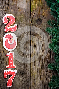 New Year's concept. Figure 2017 from gingerbread, fir branch on a wooden background, space for text