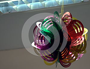 New Year`s decoration of multi-colored plastic, under the ceiling, reinforced on the office lamp.