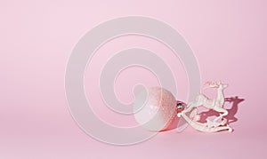 New Year\'s decorations on a pink background. Reindeer and a big ball of white and pink color, sparkling. Conceptual settin