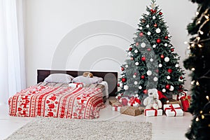New Year`s eve bedroom interior with red decor bed and Christmas tree with gifts