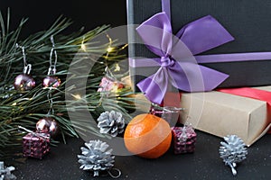 New Year`s Eve christmas background. Gifts boxes in a package with bows ribbons lie next to the spruce pine burning festive