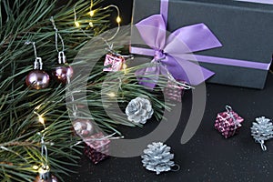 New Year`s Eve christmas background. Gifts boxes in a package with bows ribbons lie next to the spruce pine burning festive