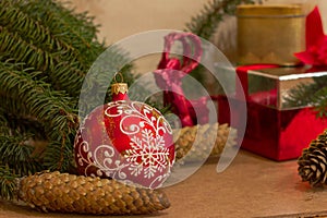 New Year`s eve with a red Christmas ball, cones, spruce branches, Christmas tree toy and gift boxes