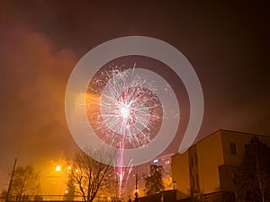 New Year`s fireworks create smoke over houses on the outskirts of the city - Long exposure at night on New Year