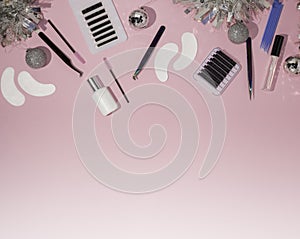 New year`s flatley. Tools for eyelash extension on a pink background, top view. Patches, artificial eyelashes, brushes, glue,
