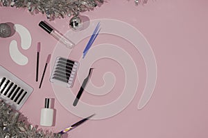 New year`s flatley. Tools for eyelash extension on a pink background, top view. Patches, artificial eyelashes, brushes, glue,