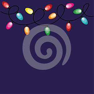 New Year\'s garland of multi-colored light bulbs on a dark blue background with a place for text