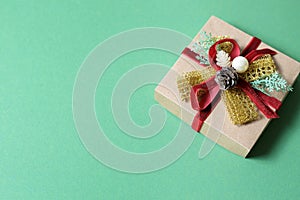 New Year`s gift in craft paper on a plain green background photo