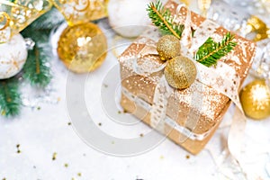 New Year's gift in a golden box, decorated with bart, Christmas tree branches and Christmas toys