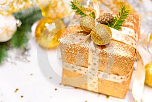 New Year`s gift in a golden box, decorated with bart, Christmas tree branches and Christmas toys